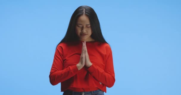 Молода жінка молиться перед камерою — стокове відео