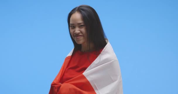 Молода жінка, закутана в канадійський прапор, танцює. — стокове відео