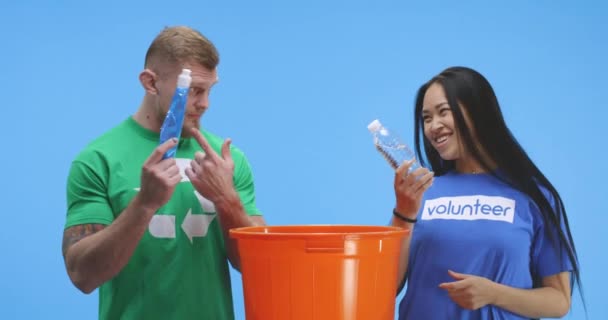 エコ意識の高い男と女がバケツに瓶を入れる — ストック動画
