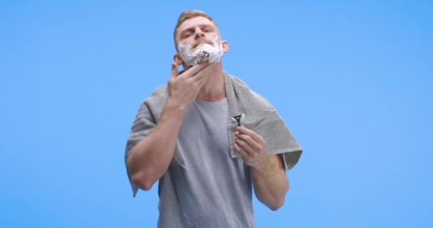 男人一边刮胡子一边看相机 — 图库视频影像