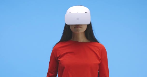 Młoda kobieta nosi zestaw słuchawkowy VR i wykonuje gesty dłoni — Wideo stockowe
