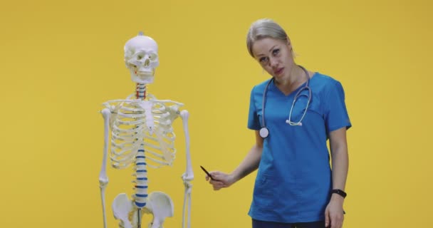 Doctor explicando anatomía con esqueleto — Vídeo de stock