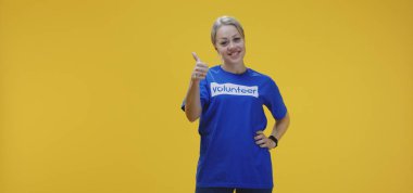 Kadın gönüllü kameraya gülümsüyor.