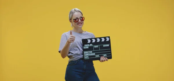 Glada kvinna klappa clapperboard — Stockfoto