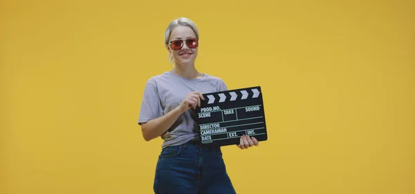 Cheerful woman clapping clapperboard — 스톡 사진
