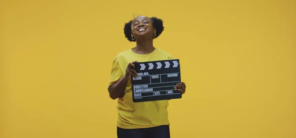 Cheerful woman clapping clapperboard — 스톡 사진