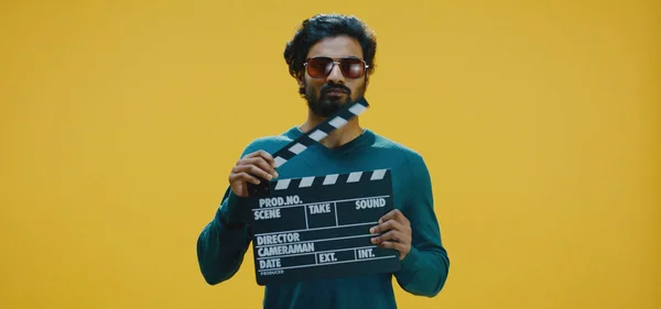 Bored man clapping clapperboard — Stock Photo, Image