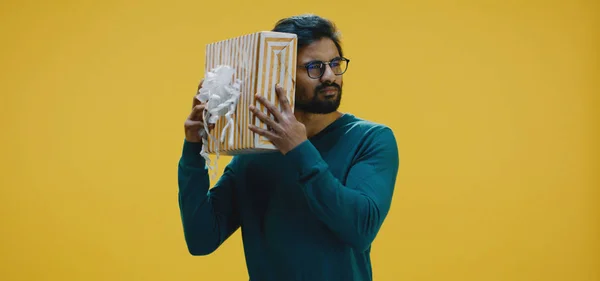 Młody człowiek łapie pudełko prezentów — Zdjęcie stockowe