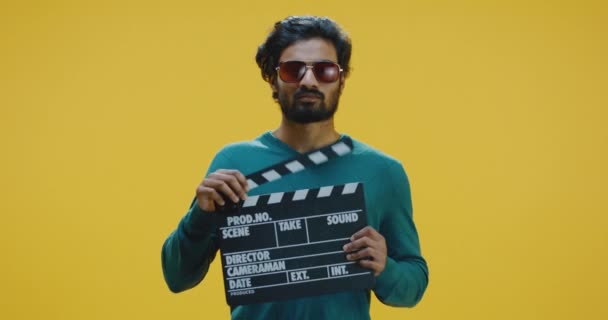 Cheerful man clapping clapperboard — Stock Video
