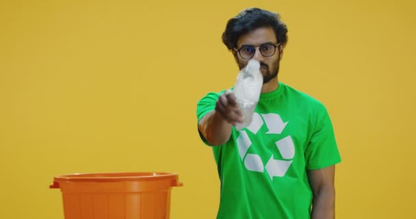 Экологически сознательный человек кладет бутылку в ведро — стоковое видео