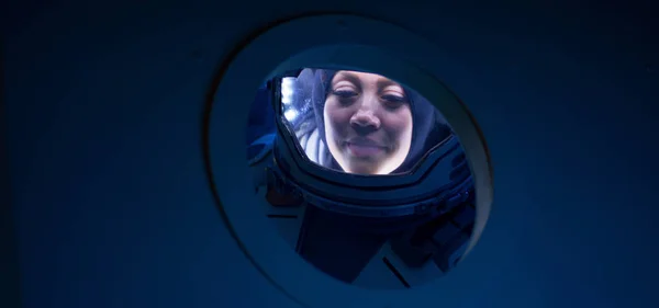 Γυναίκα αστροναύτης που κοιτάζει έξω από το φινιστρίνι διαστημόπλοιο — Φωτογραφία Αρχείου