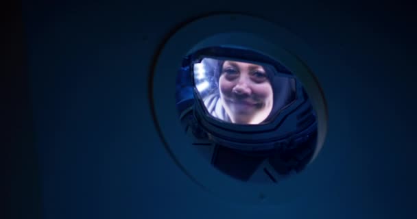 Astronauta femenina saludando a la cámara desde una nave espacial — Vídeo de stock