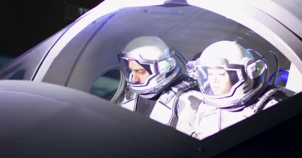Male and female astronauts navigating spaceship — Stock Video