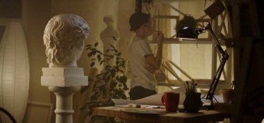 Genç ressam masada çizim yapıyor.