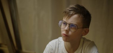 Çocuk yemek yerken resme bakıyor.