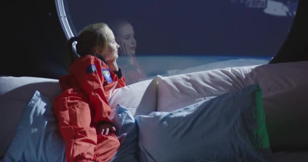 Meisje kijkt uit ruimteschip raam — Stockvideo