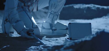 Astronot örnek toplamak için ekipman kullanıyor