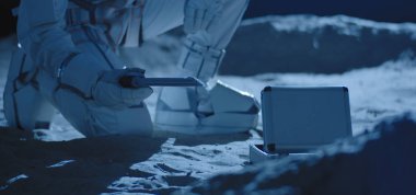 Astronot örnek toplamak için ekipman kullanıyor