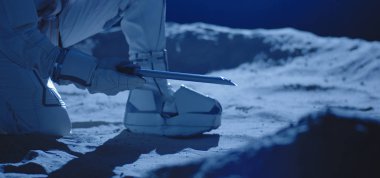 Astronot örnek toplamak için ekipman kullanıyor