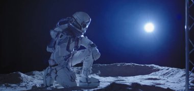 Astronot Ay 'da diz çöküyor.