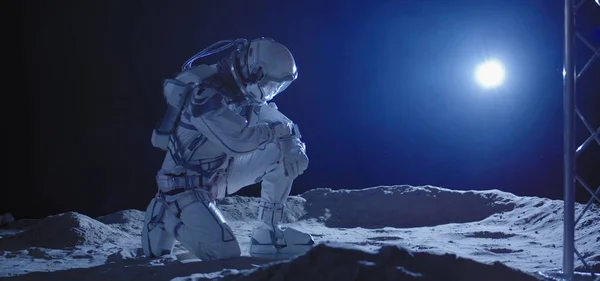 Космонавт на коленях на Луне — стоковое фото