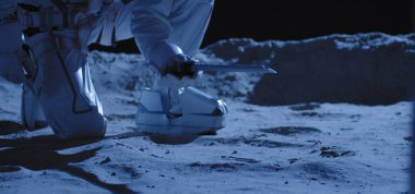 Astronot örnek toplamak için ekipman kullanıyor