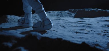 Astronot örnek toplamak için ekipman kullanıyor