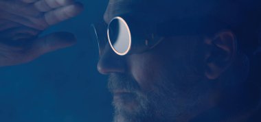 Güvenlik gözlüklü adam başka tarafa bakıyor.