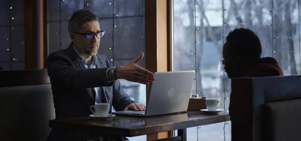 Businessman talking with client in cafe