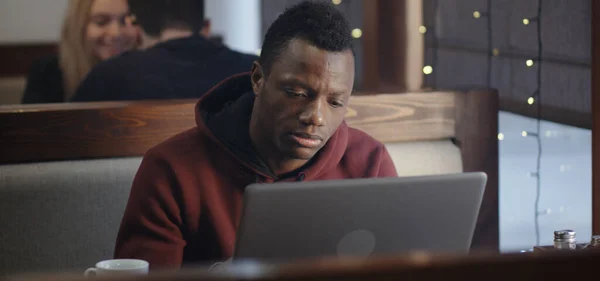 Молодий чоловік працює на ноутбуці в кафе — стокове фото