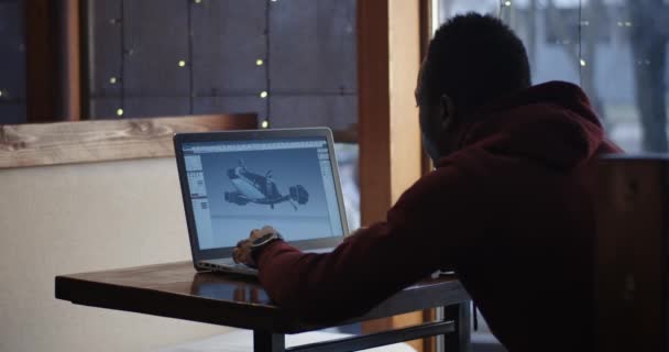 Графический дизайнер, работающий над ноутбуком в кафе — стоковое видео