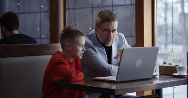 Padre e hijo usando el ordenador portátil juntos — Vídeo de stock