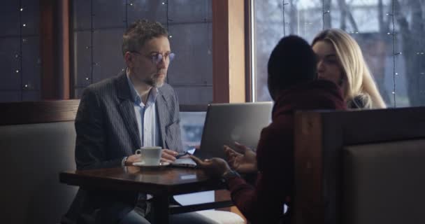 Young man showing smartphone to businessman — 비디오