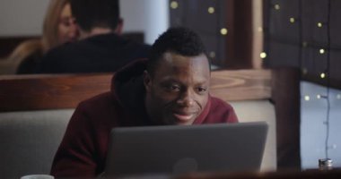 Cafe 'de laptopta çalışan genç adam.