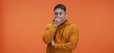 Young man tiredly yawning