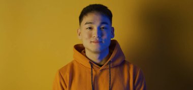 Young man smiling against yellow background