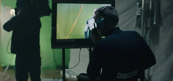 Diretor dando instruções e assistindo a cena no monitor — Fotografia de Stock