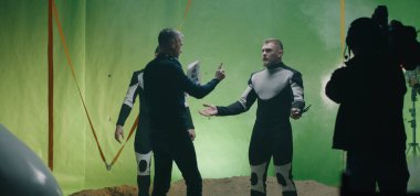 Director watching a shooting and discussing with an actor