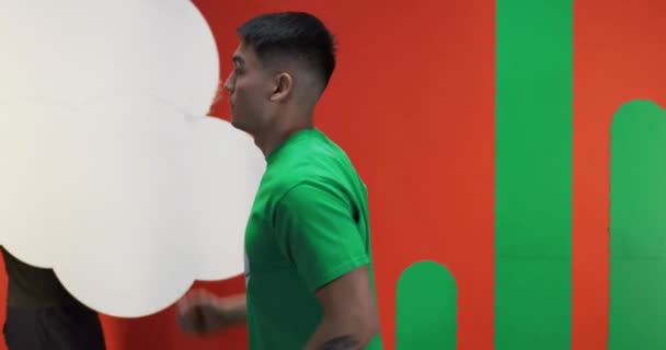 Young man jogging against orange background — Αρχείο Βίντεο