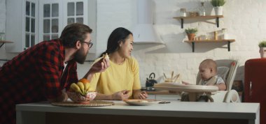 Bebekleriyle kahvaltı eden genç bir çift.