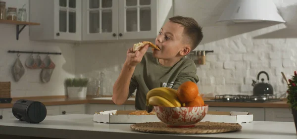 Menino comendo na cozinha sozinho — Fotografia de Stock