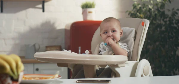 Baby spelen in een hoge stoel — Stockfoto