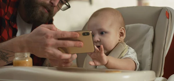 पिता बच्चे को स्मार्टफ़ोन दिखा रहा है — स्टॉक फ़ोटो, इमेज