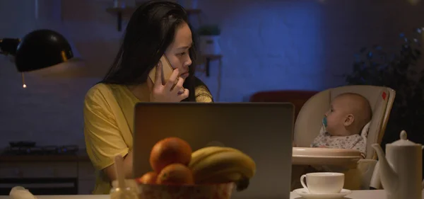 Young mother with baby working on laptop — Stock Photo, Image