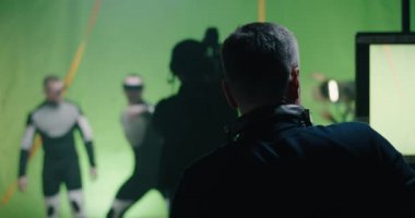 Director watching a shooting and discussing with an actor