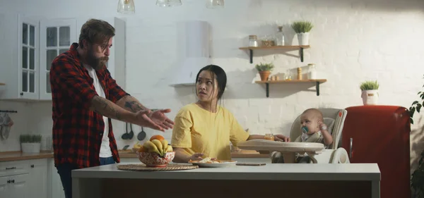 Jovem casal tomando café da manhã com seu bebê — Fotografia de Stock