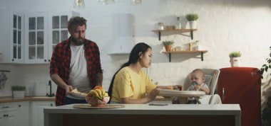 Bebekleriyle kahvaltı eden genç bir çift.