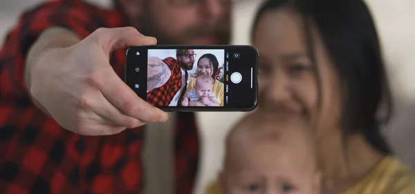 Młoda para robi selfie z dzieckiem — Zdjęcie stockowe