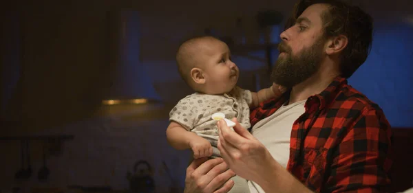 Vader voedt 's nachts een baby — Stockfoto