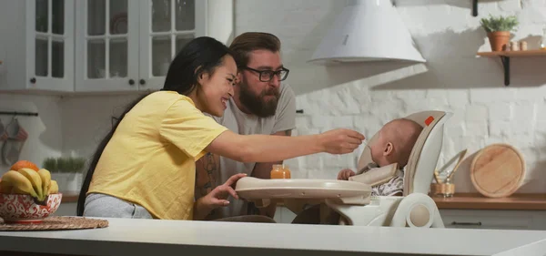 Madre alimentando a su bebé en la cocina — Foto de Stock